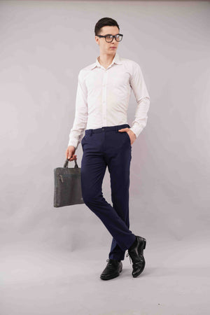 Man wearing a white shirt, blue flexiwaist pants and black shoes holding a black briefcase
