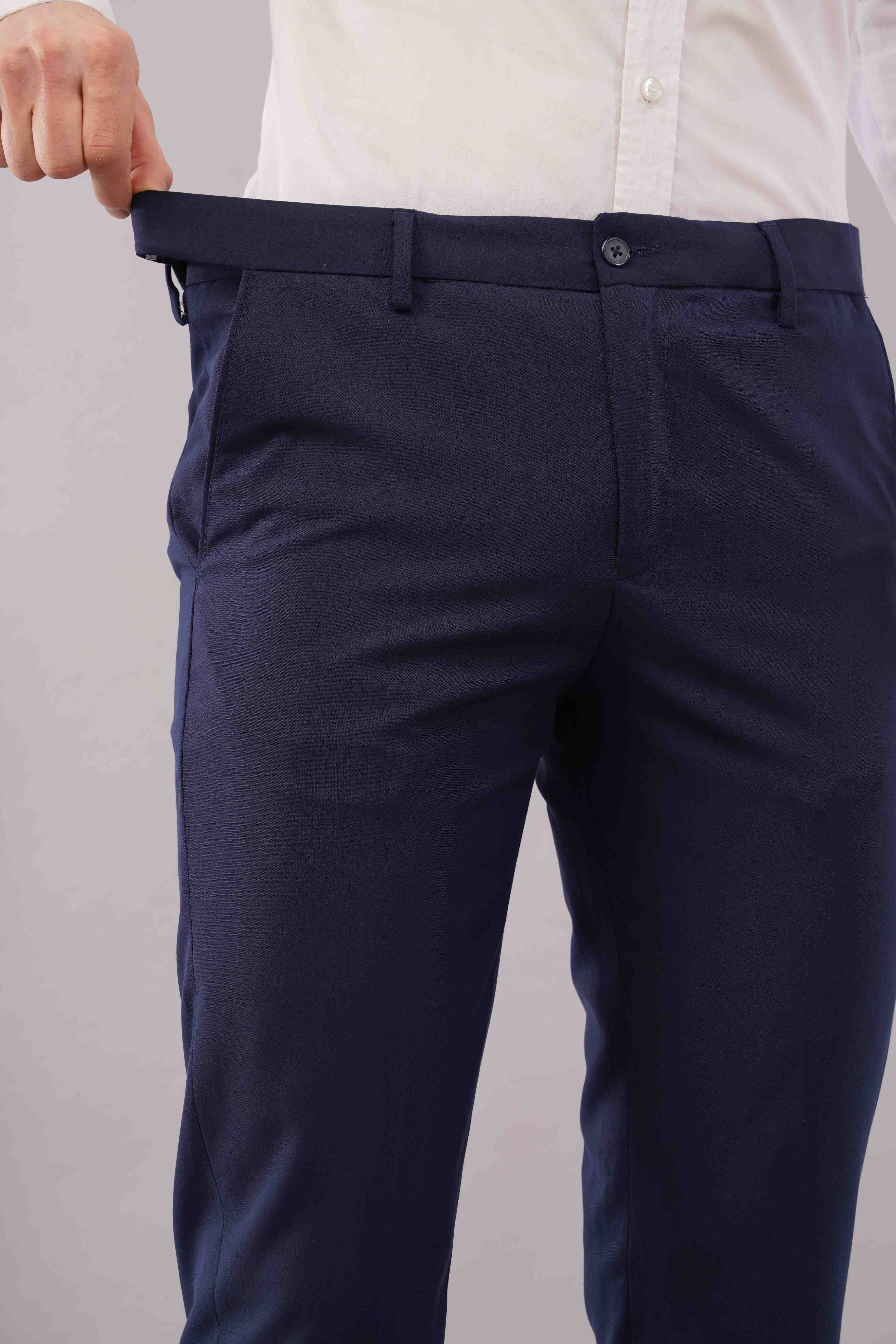 blue formal pants being worn on a plain background