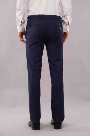 Person wearing blue pants and a white shirt on a plain background