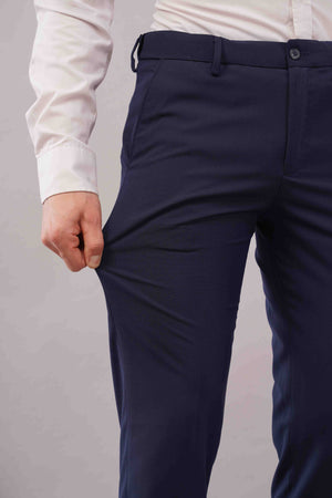 blue formal pants worn with a white shirt on a grey background