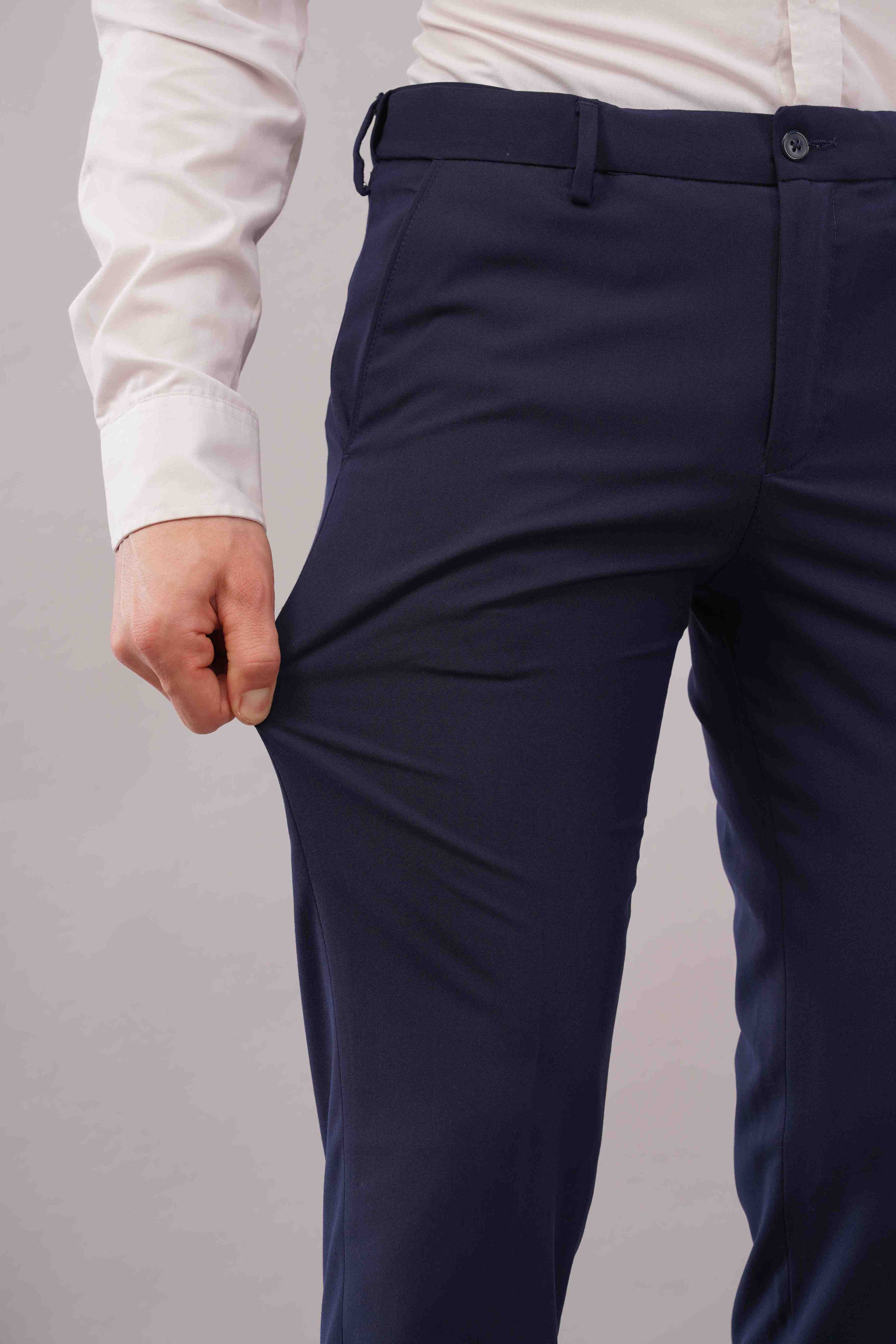blue formal pants worn with a white shirt on a grey background